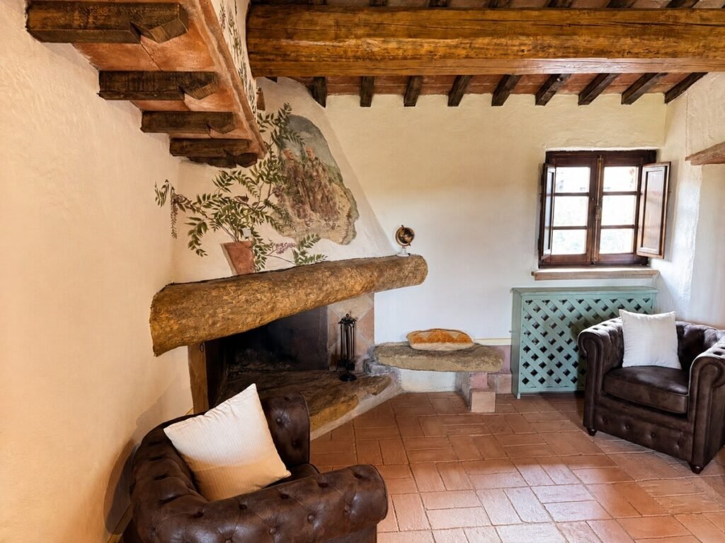 Soggiorno con camino, divano e finestra nell'appartamento Il belvedere, Borgo Braila, Umbria