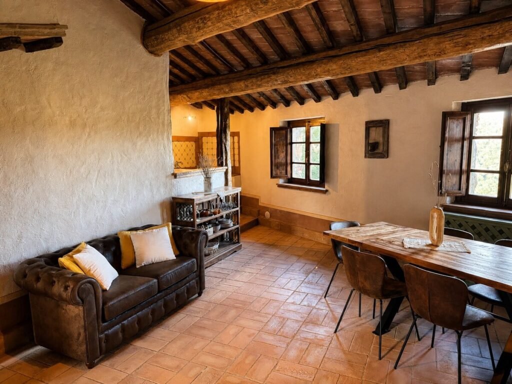 Soggiorno con divano, tavolo da pranzo e finestra nell'appartamento Il belvedere, Borgo Braila, Umbria