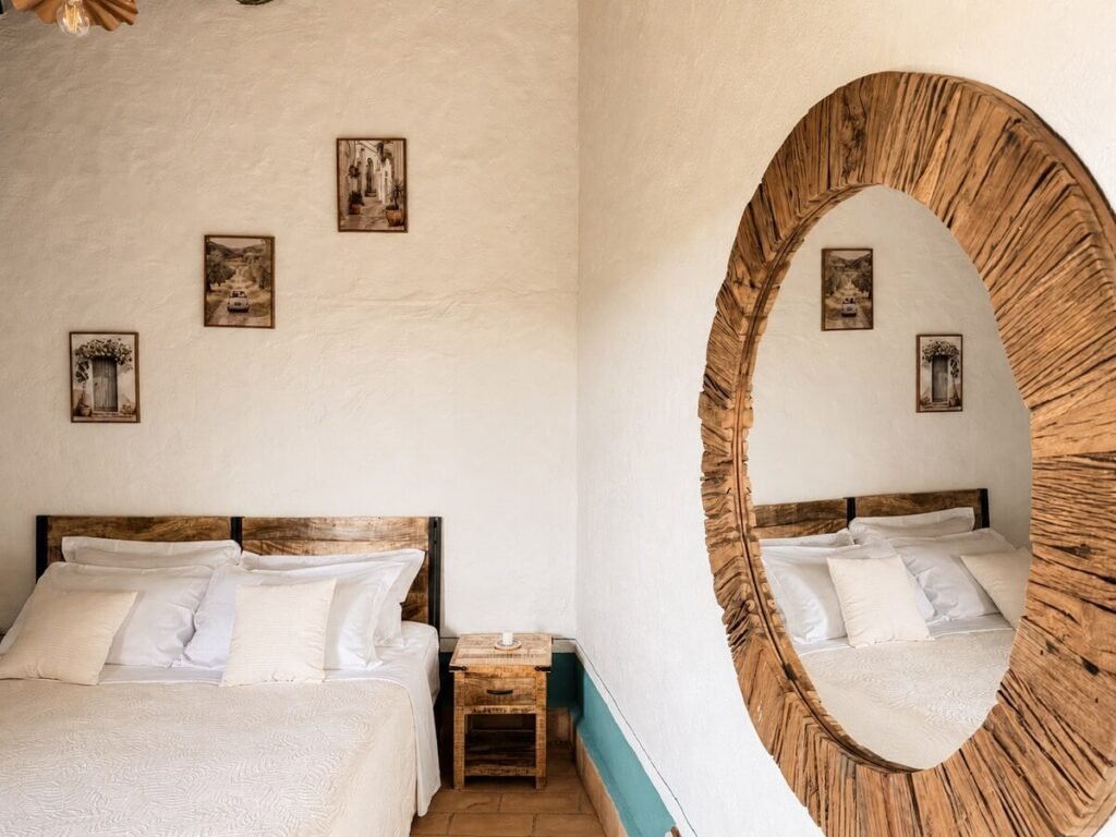 Camera da letto con letto matrimoniale e specchio rotondo nell'appartamento Il belvedere, Borgo Braila, Umbria