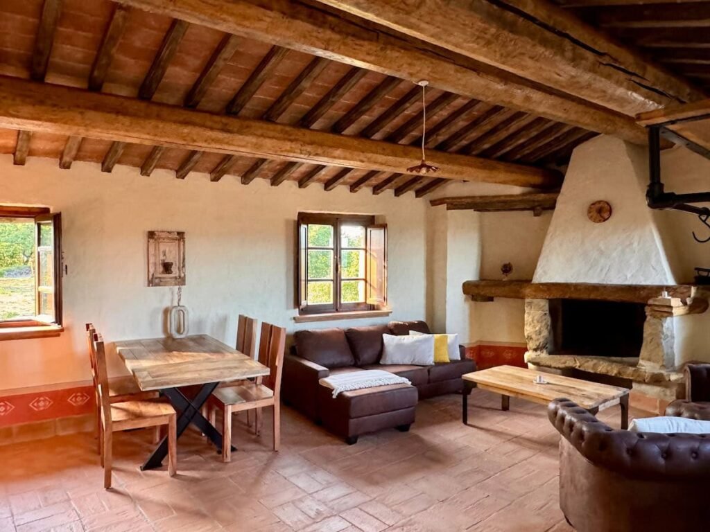Soggiorno con camino e tavolo da pranzo rustico nell'appartamento Il cavaliere, Borgo Braila, Umbria