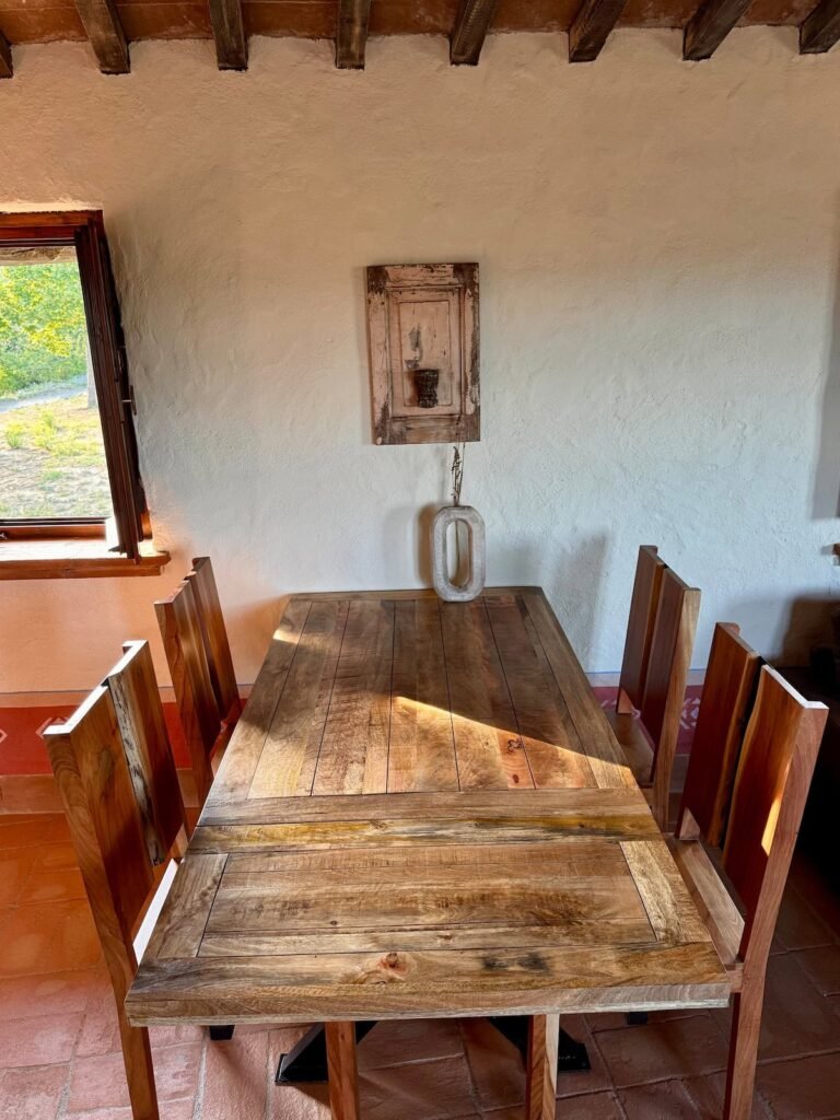 Tavolo da pranzo rustico in legno accanto alla finestra nell'appartamento Il cavaliere, Borgo Braila, Umbria