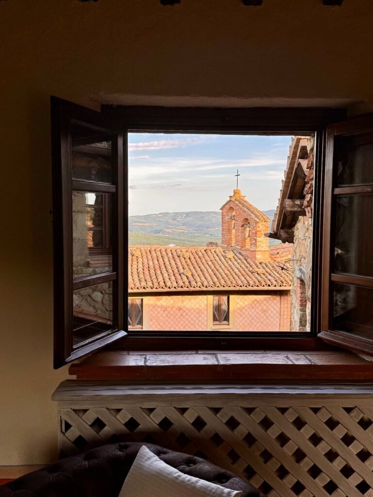 Finestra che incornicia la vista sul borgo medievale nell'appartamento Il cavaliere, Borgo Braila, Umbria