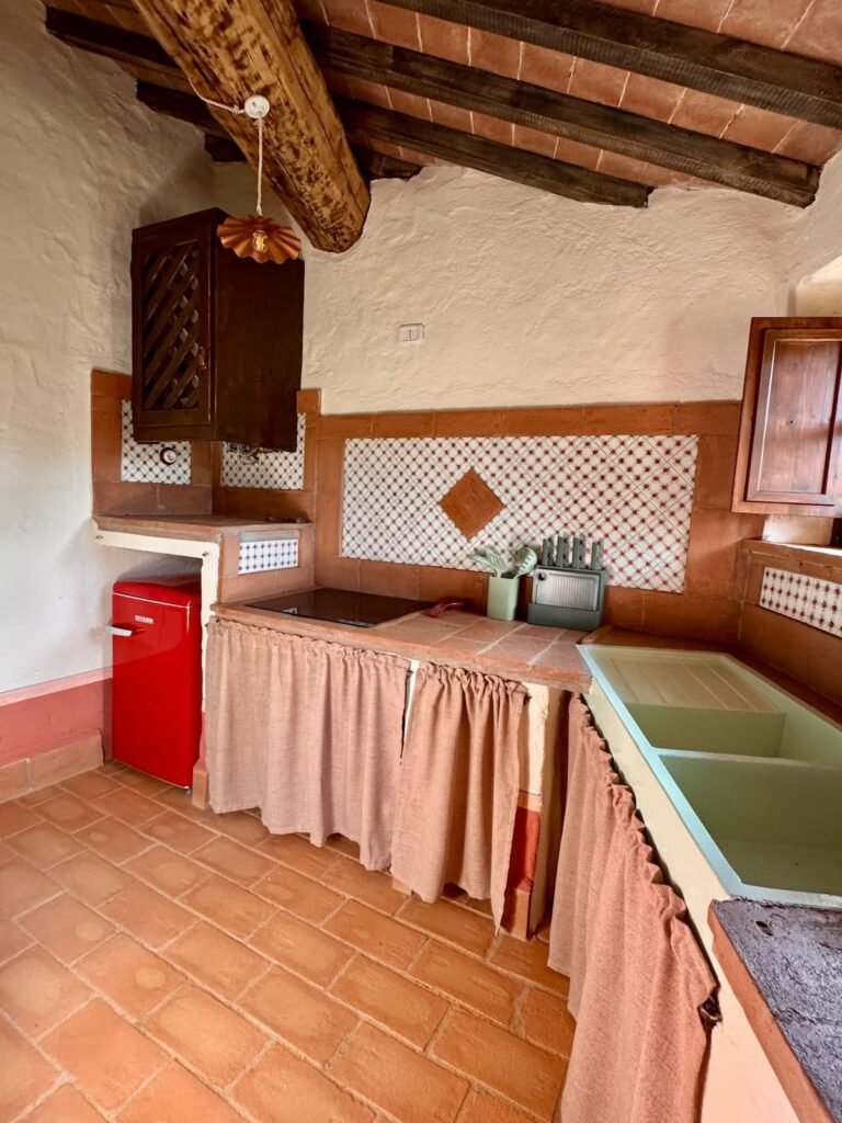 Cucina rustica con frigorifero rosso retrò nell'appartamento Il cavaliere, Borgo Braila, Umbria