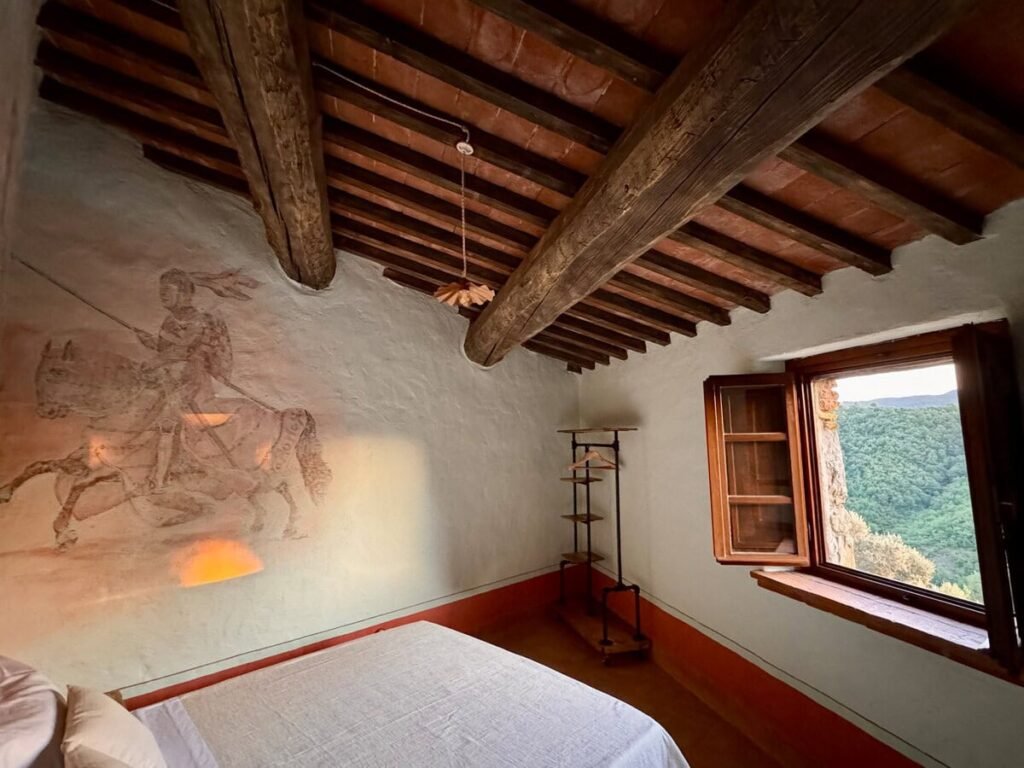 Camera da letto con affresco del cavaliere dipinto a mano nell'appartamento Il cavaliere, Borgo Braila, Umbria