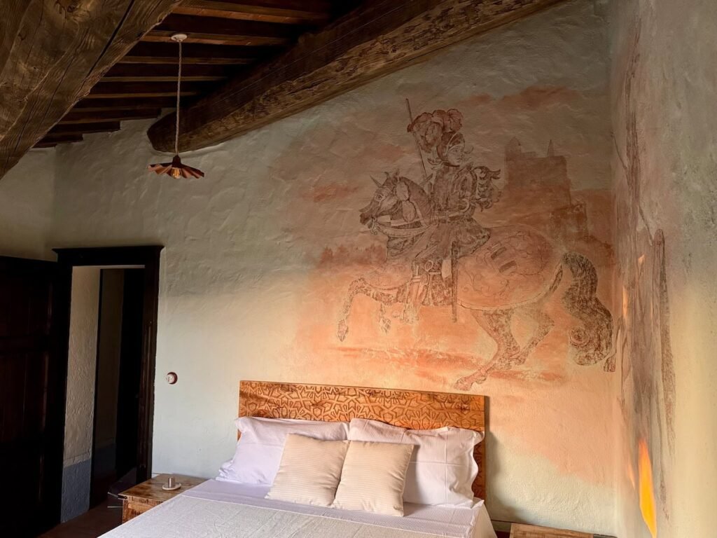 Camera da letto con affresco murale del cavaliere a cavallo nell'appartamento Il cavaliere, Borgo Braila, Umbria
