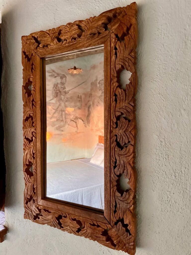 Dettaglio di uno specchio da parete in legno intagliato nell'appartamento Il cavaliere, Borgo Braila, Umbria
