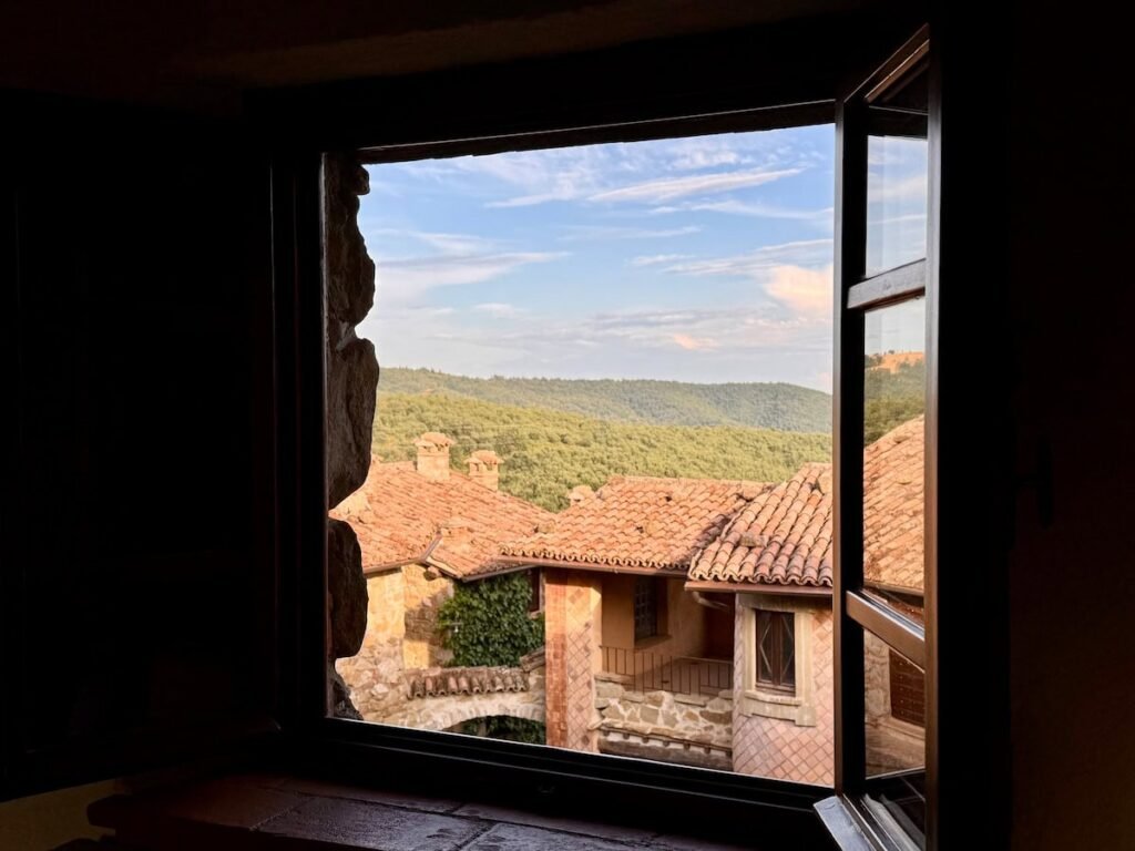 Finestra aperta con vista panoramica sul borgo e sulle colline umbre nell'appartamento Il cavaliere, Borgo Braila, Umbria