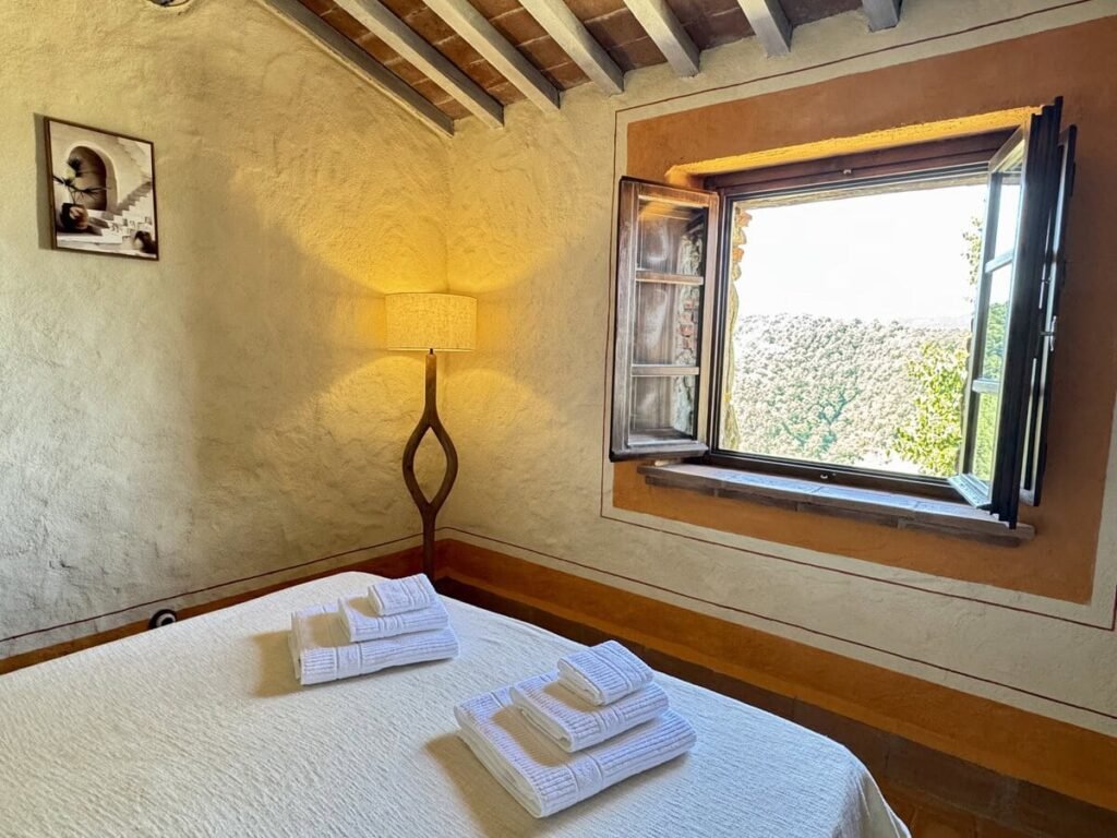 Camera da letto con letto matrimoniale e finestra nell'appartamento La carta, Borgo Braila, Umbria