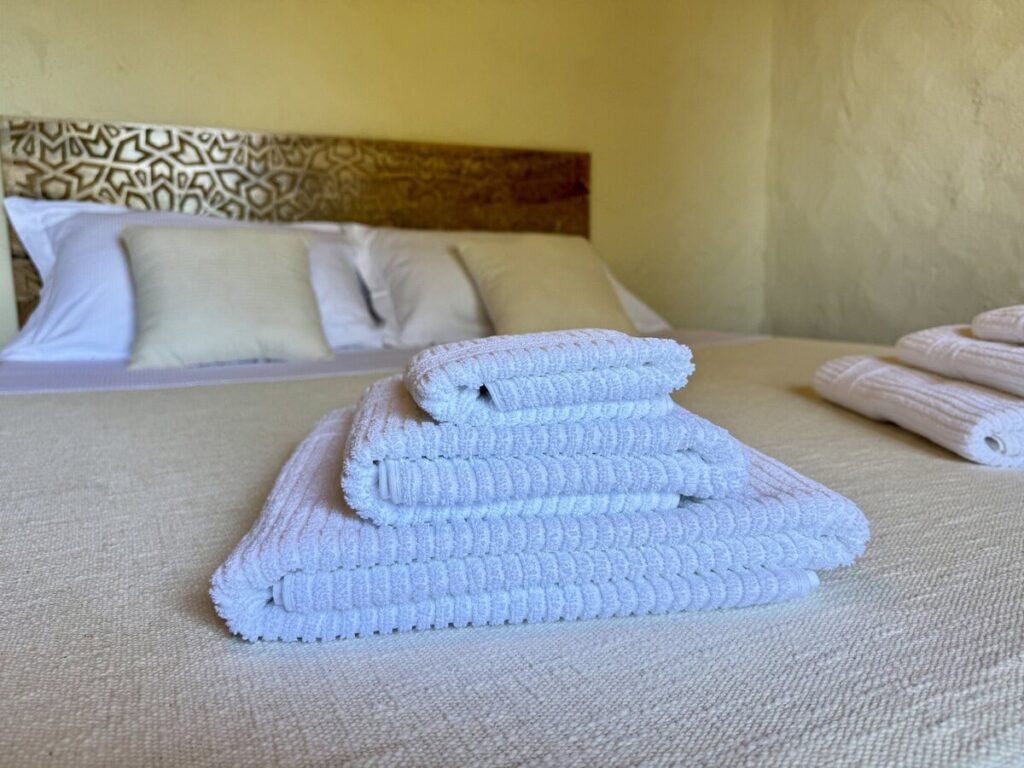 Camera da letto con letto matrimoniale e asciugamani freschi nell'appartamento La carta, Borgo Braila, Umbria