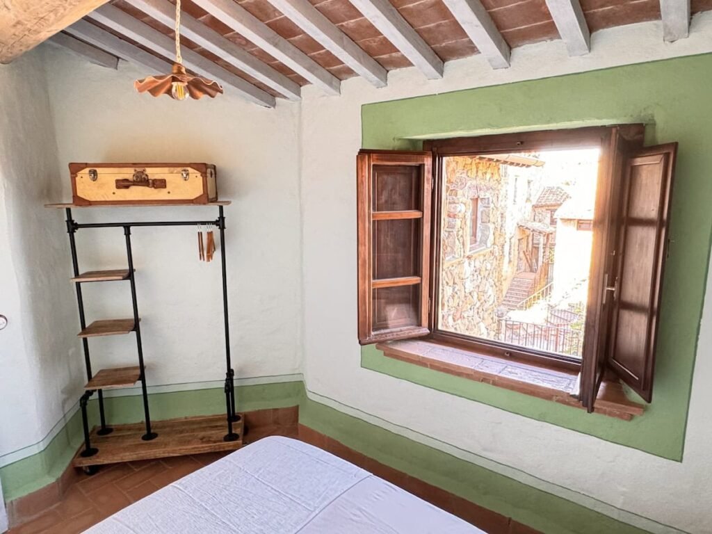 Camera da letto con letto e finestra nell'appartamento La carta, Borgo Braila, Umbria