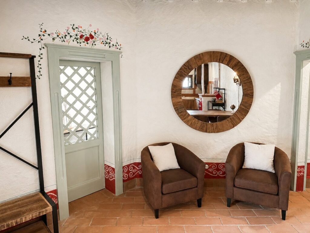 Soggiorno con specchio rotondo e poltrone nell'appartamento Il ponente, Borgo Braila, Umbria