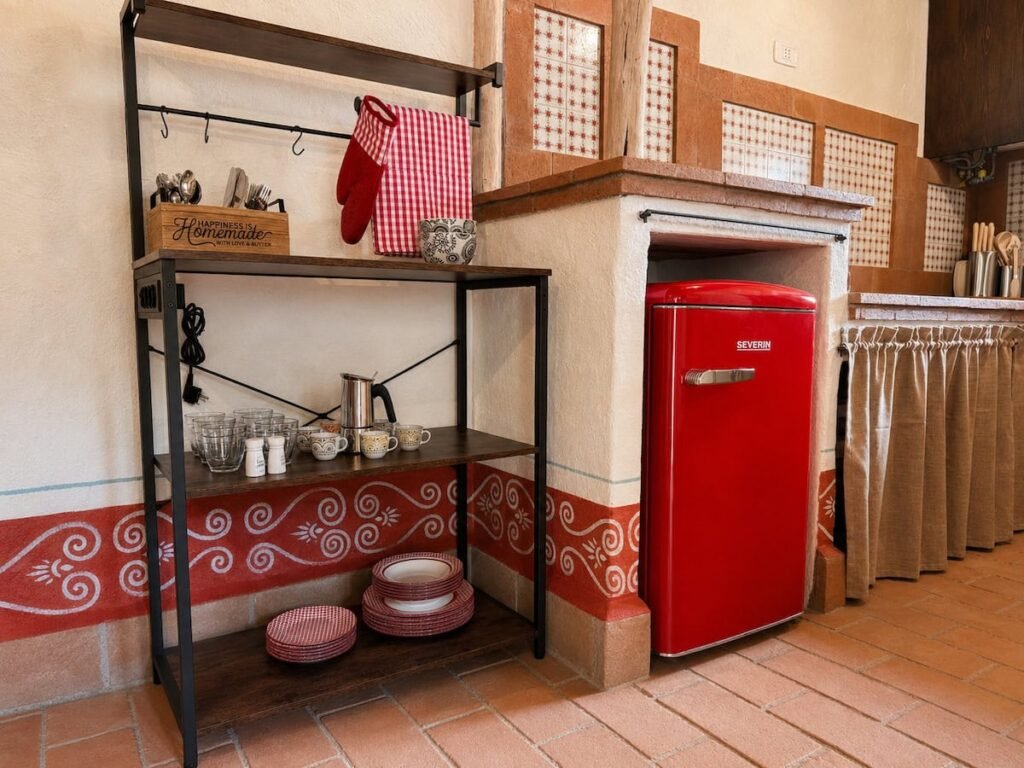 Cucina rustica con frigorifero rosso retrò nell'appartamento Il ponente, Borgo Braila, Umbria