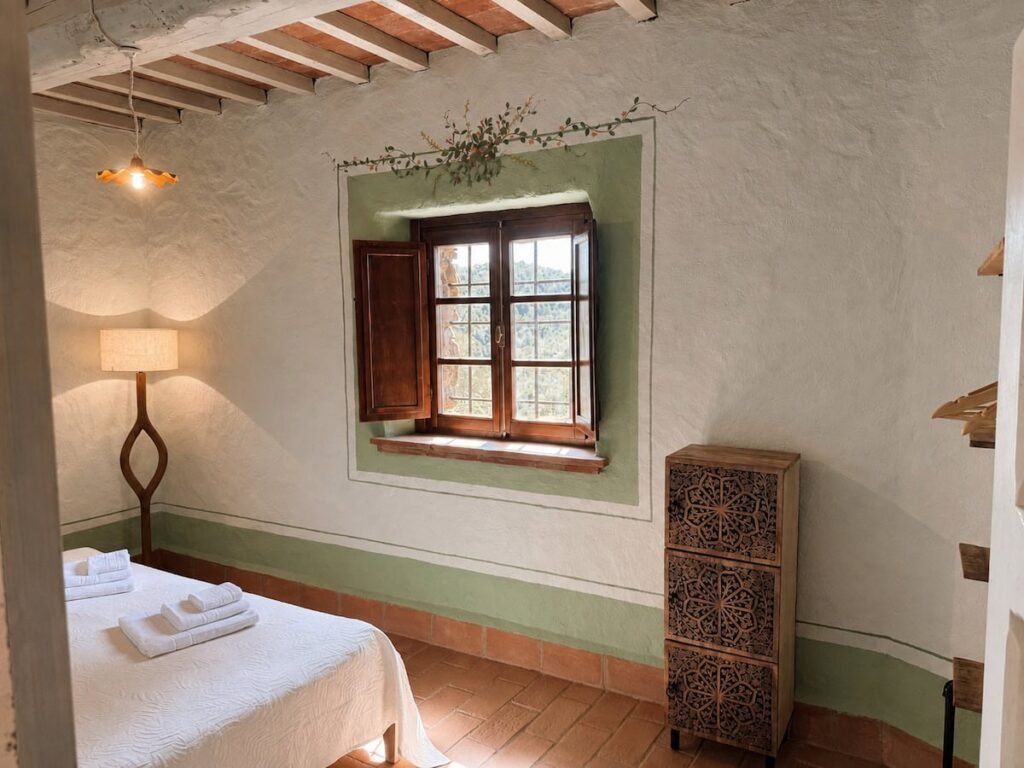 Camera da letto con letto e finestra nell'appartamento Il ponente, Borgo Braila, Umbria