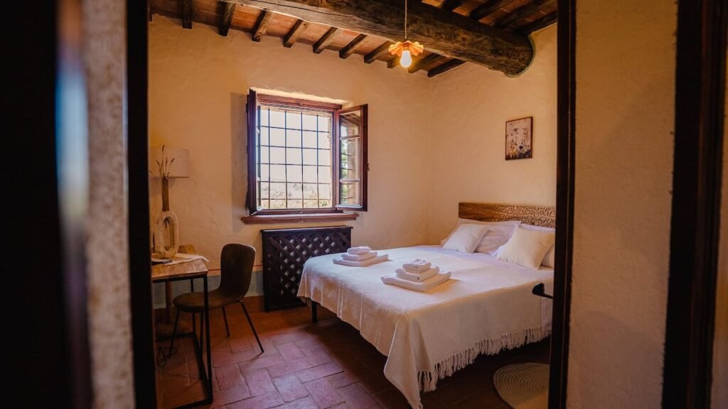 Camera da letto con letto matrimoniale e finestra nell'appartamento Il cardinale, Borgo Braila, Umbria