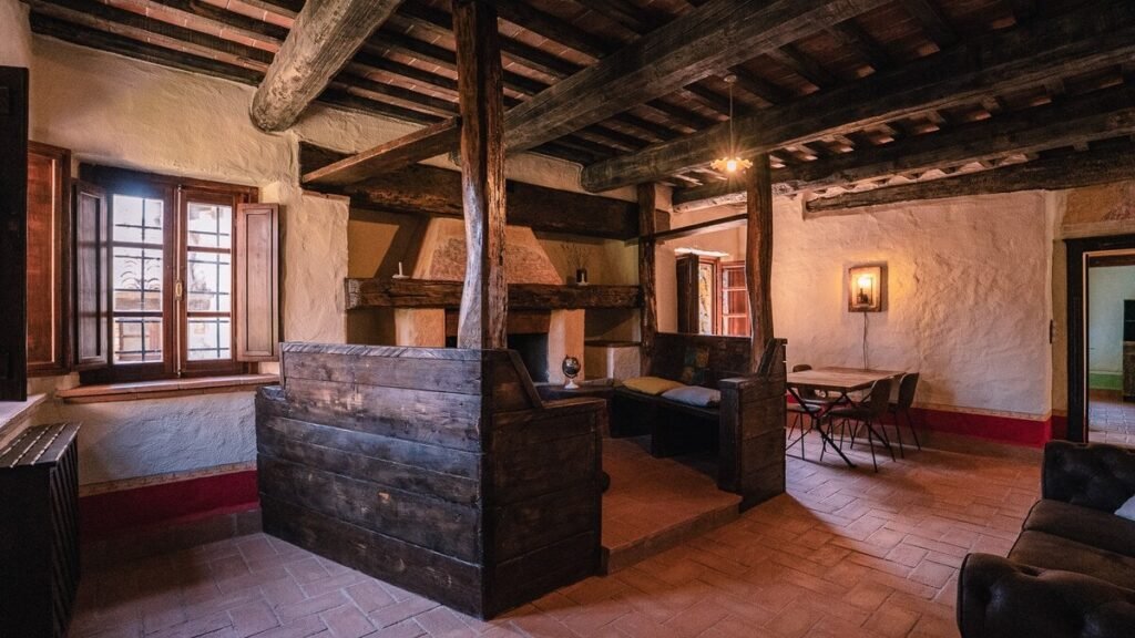 Zona giorno e cucina con travi a vista nell'appartamento Il cardinale, Borgo Braila, Umbria