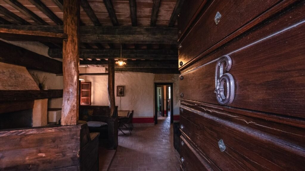 Soggiorno con credenza in legno scuro nell'appartamento Il cardinale, Borgo Braila, Umbria