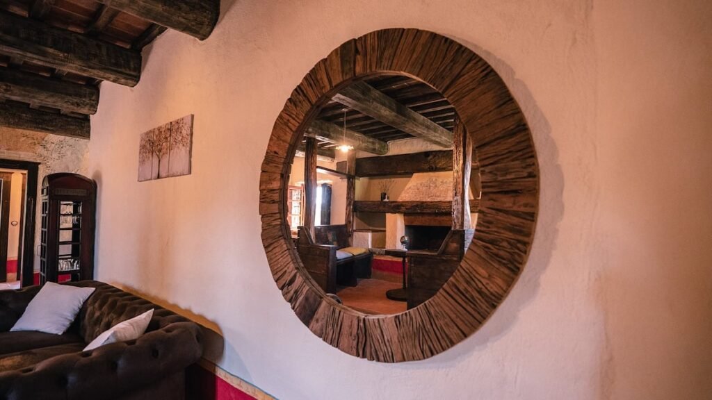 Soggiorno con specchio rotondo nell'appartamento Il cardinale, Borgo Braila, Umbria