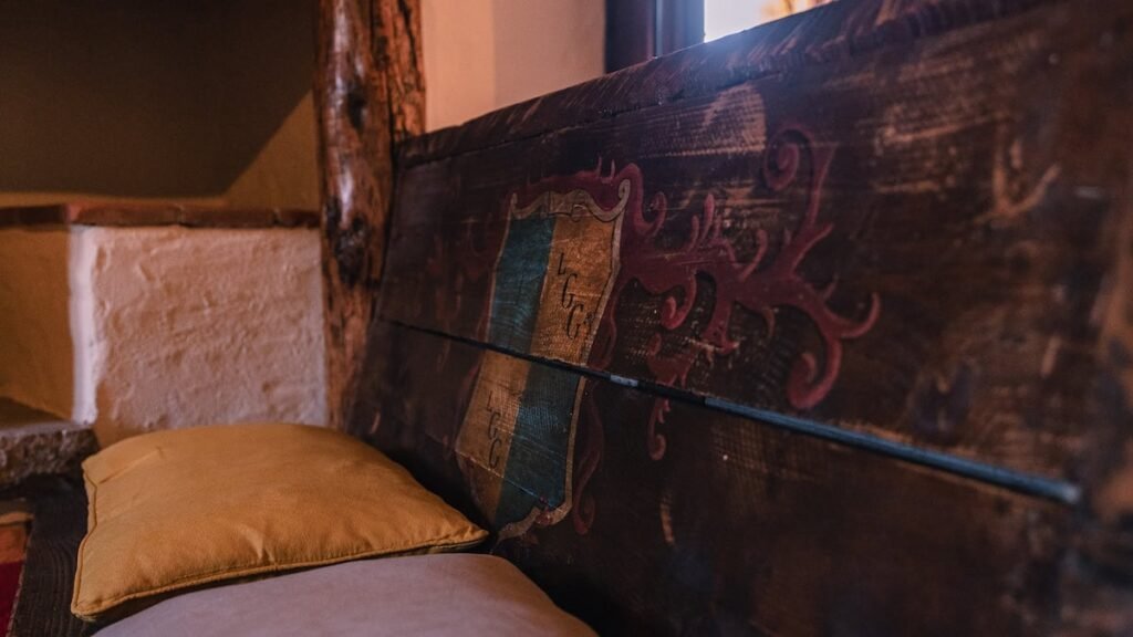 Dettaglio di una trave in legno dipinta a mano nell'appartamento Il cardinale, Borgo Braila, Umbria
