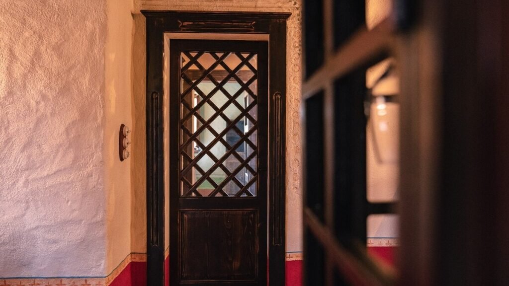 Porta in legno con finestra a grata nell'appartamento Il cardinale, Borgo Braila, Umbria