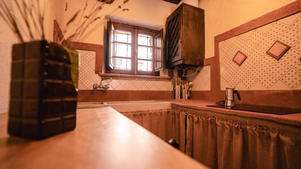 Cucina con scaffalature e finestra nell'appartamento Il cardinale, Borgo Braila, Umbria