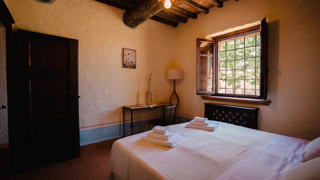 Camera da letto con letto matrimoniale e finestra nell'appartamento Il cardinale, Borgo Braila, Umbria