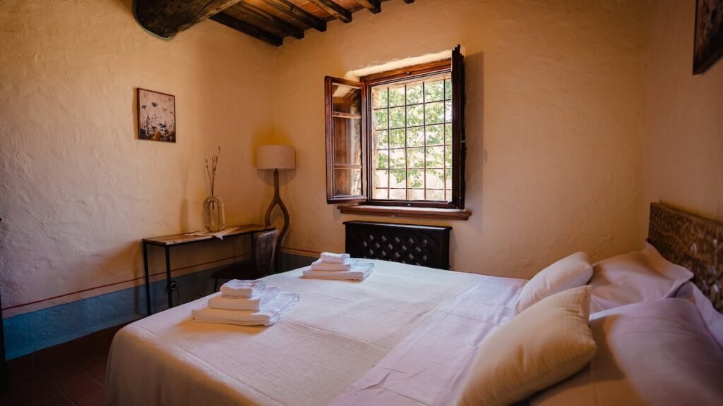 Camera da letto con letto matrimoniale e finestra nell'appartamento Il cardinale, Borgo Braila, Umbria