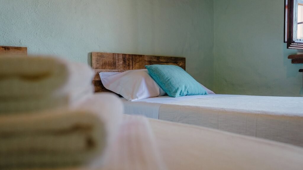Letti singoli con plaid verdi nell'appartamento Il cardinale, Borgo Braila, Umbria