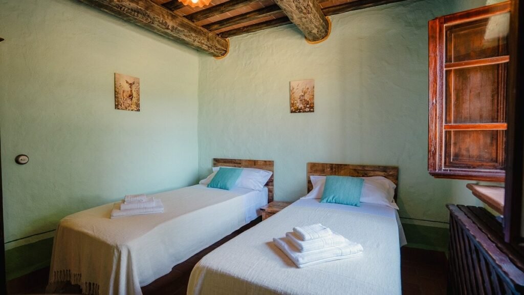 Camera da letto con due letti e una finestra nell'appartamento Il cardinale, Borgo Braila, Umbria