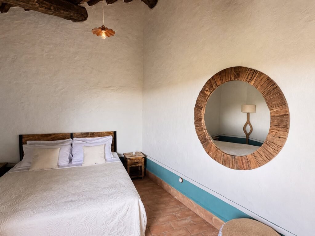 Camera da letto con travi a vista e materiali naturali nell'appartamento Il belvedere, Borgo Braila