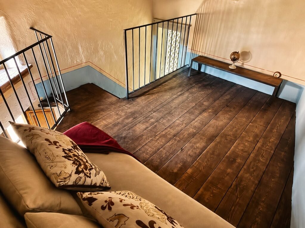 Camera da letto con travi a vista e materiali naturali in un appartamento di Borgo Braila, Borgo Braila