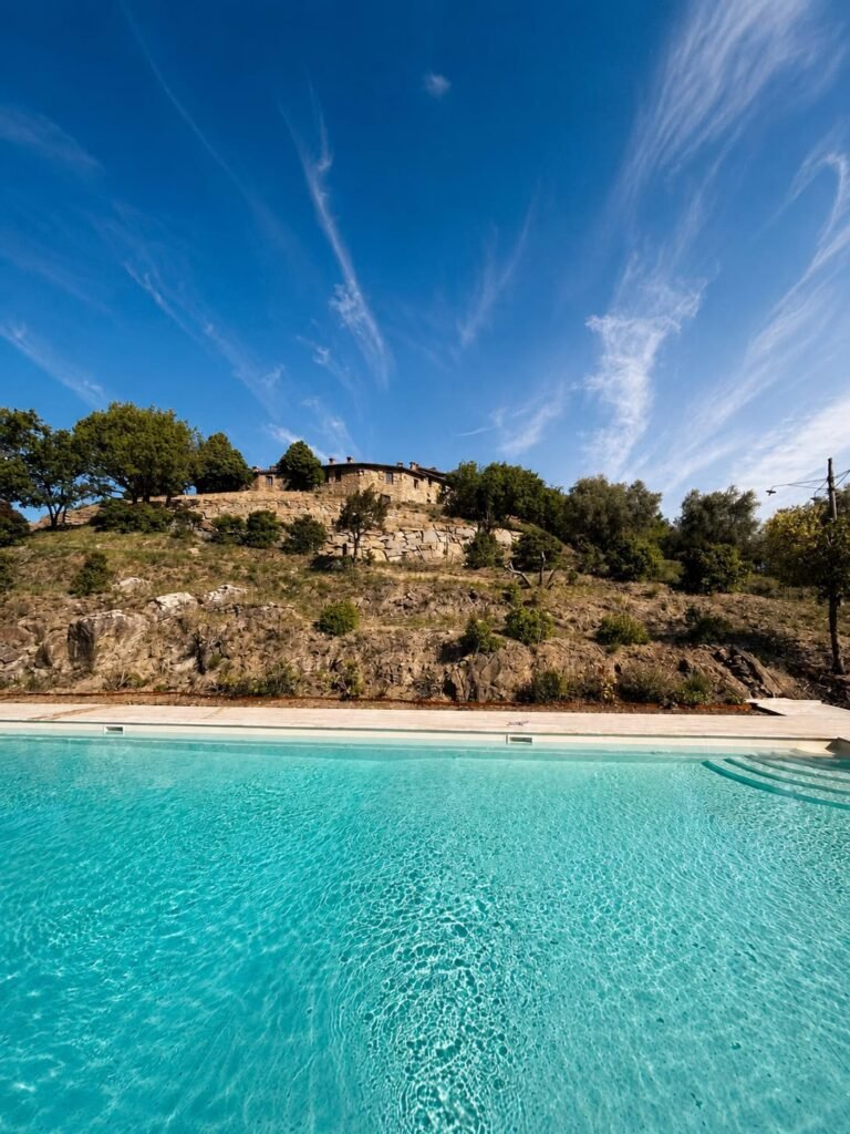 Piscina panoramica in travertino affacciata sulle colline umbre a Borgo Braila