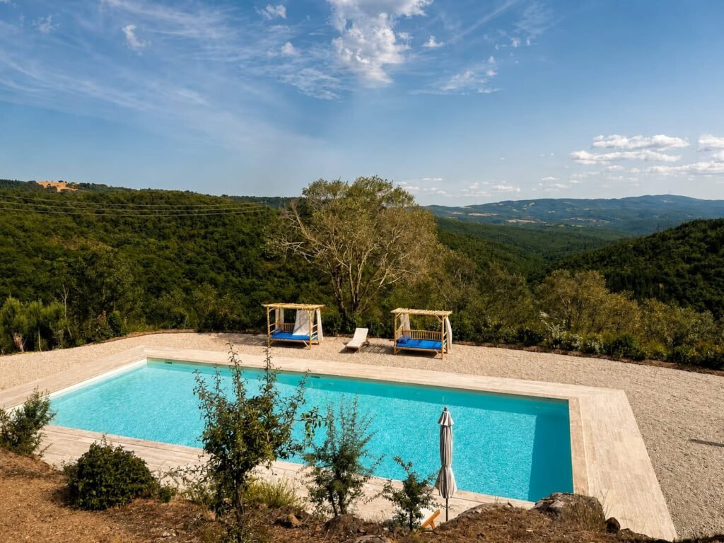Piscina panoramica in travertino affacciata sulle colline umbre a Borgo Braila