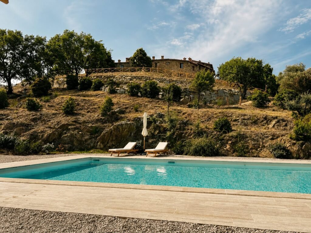 Piscina panoramica in travertino affacciata sulle colline umbre a Borgo Braila