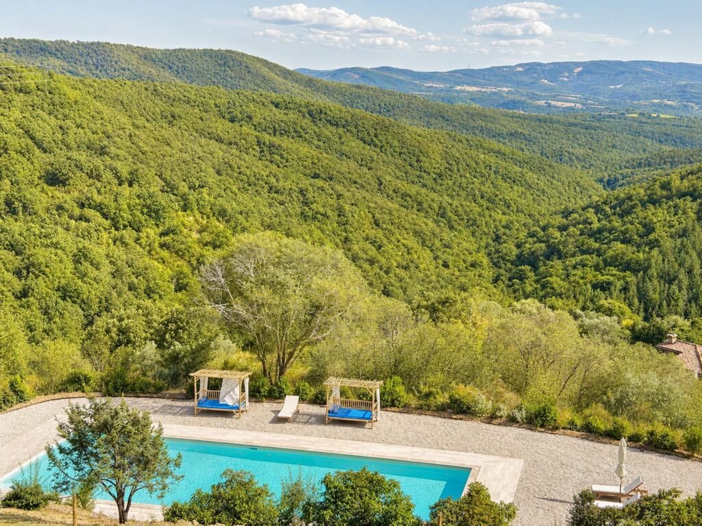Piscina in travertino con vista panoramica sulla valle umbra a Borgo Braila
