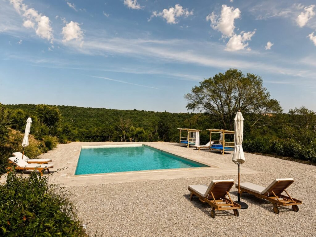 Piscina panoramica in travertino affacciata sulle colline umbre a Borgo Braila