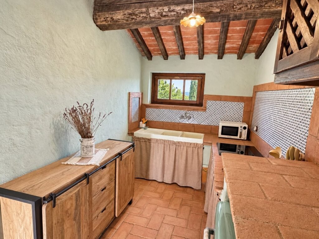Cucina con credenza in legno e rivestimento piastrellato nell'appartamento La Dimora del Levante, Borgo Braila, Umbria