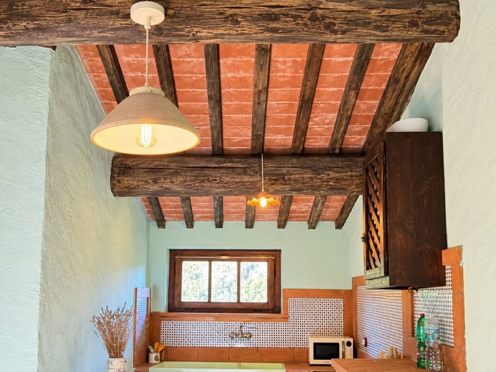 Cucina e zona pranzo sotto il soffitto a travi nell'appartamento La Dimora del Levante, Borgo Braila, Umbria