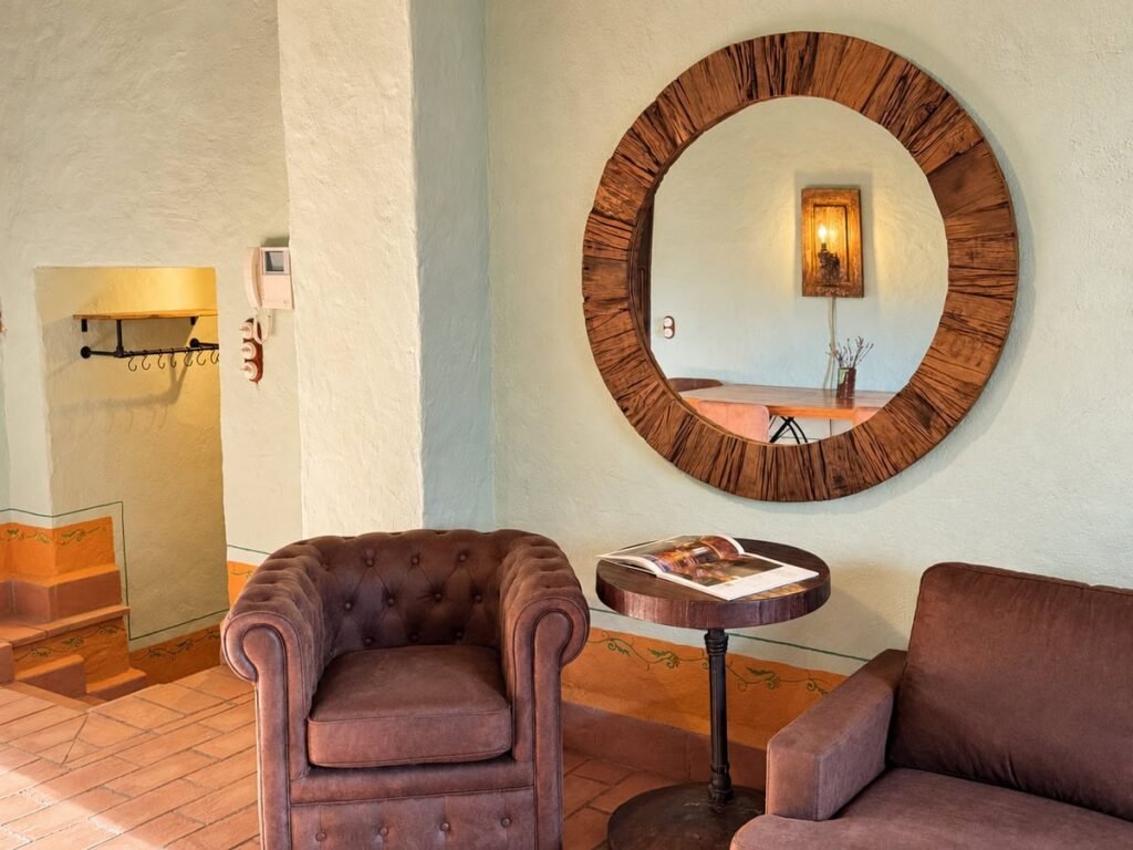 Zona salotto con poltrone e specchio rotondo nell'appartamento La Dimora del Levante, Borgo Braila, Umbria