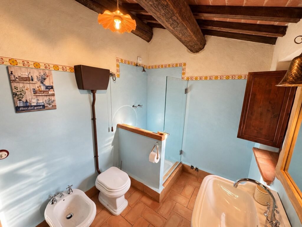 Bagno con pareti azzurre e vasca nell'appartamento La Dimora del Levante, Borgo Braila, Umbria