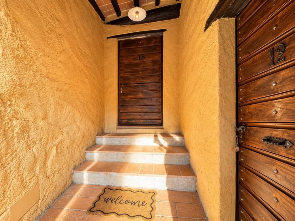 Ingresso con gradini e porta in legno nell'appartamento La Dimora del Levante, Borgo Braila, Umbria