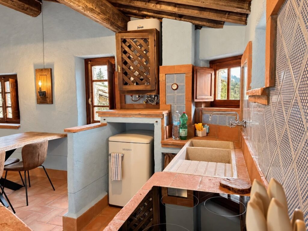 Angolo cucina con tavolo da pranzo e frigorifero rétro nell'appartamento La Casa Nobile, Borgo Braila, Umbria