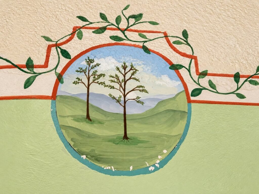 Medaglione con paesaggio dipinto a mano sulla parete del bagno nell'appartamento La Casa Nobile, Borgo Braila, Umbria