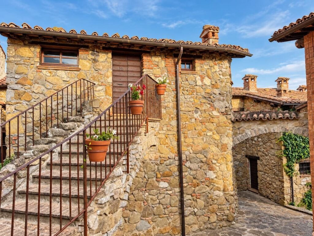 Scalinata in pietra del borgo con vasi in cotto nell'appartamento La Casa Nobile, Borgo Braila, Umbria